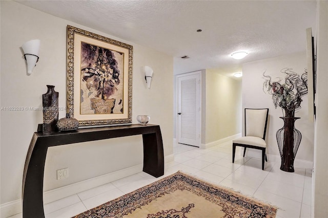 interior space featuring a textured ceiling and light tile patterned floors