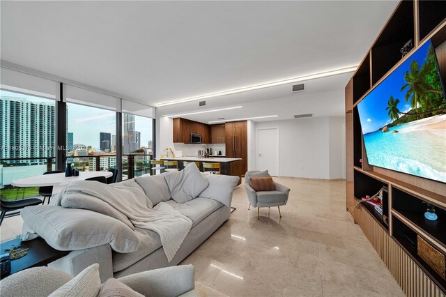 living room featuring light tile patterned flooring and a wall of windows