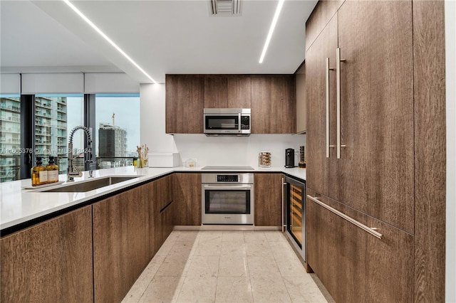 kitchen with light tile patterned flooring, sink, wine cooler, dark brown cabinetry, and appliances with stainless steel finishes