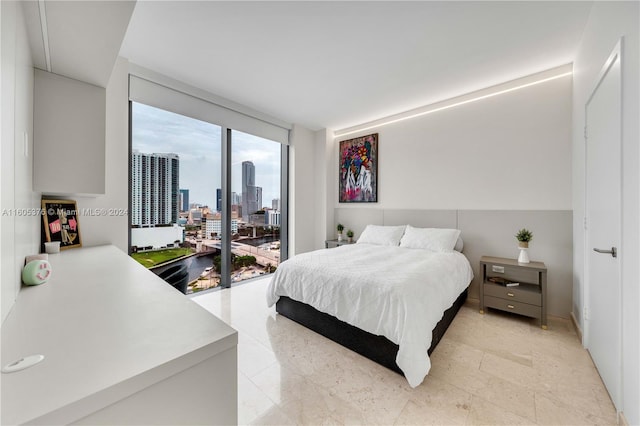 bedroom with floor to ceiling windows and light tile patterned floors