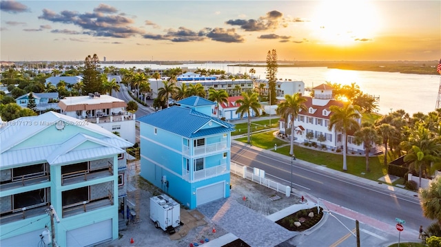 aerial view at dusk featuring a water view