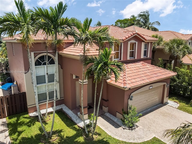 mediterranean / spanish-style home with a front yard and a garage