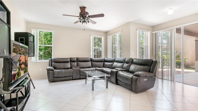 living room featuring ceiling fan, light tile patterned flooring, and a healthy amount of sunlight