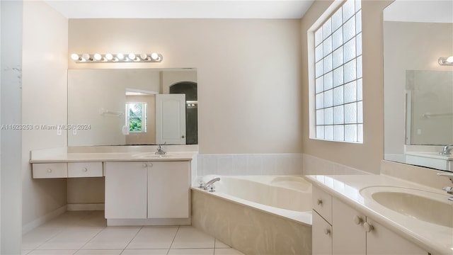 bathroom featuring dual bowl vanity, a bathing tub, and tile patterned flooring