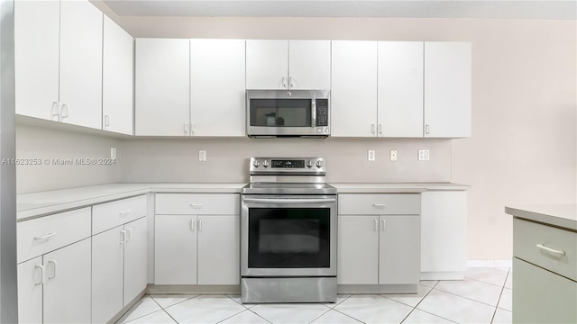 kitchen with white cabinetry, appliances with stainless steel finishes, and light tile patterned floors