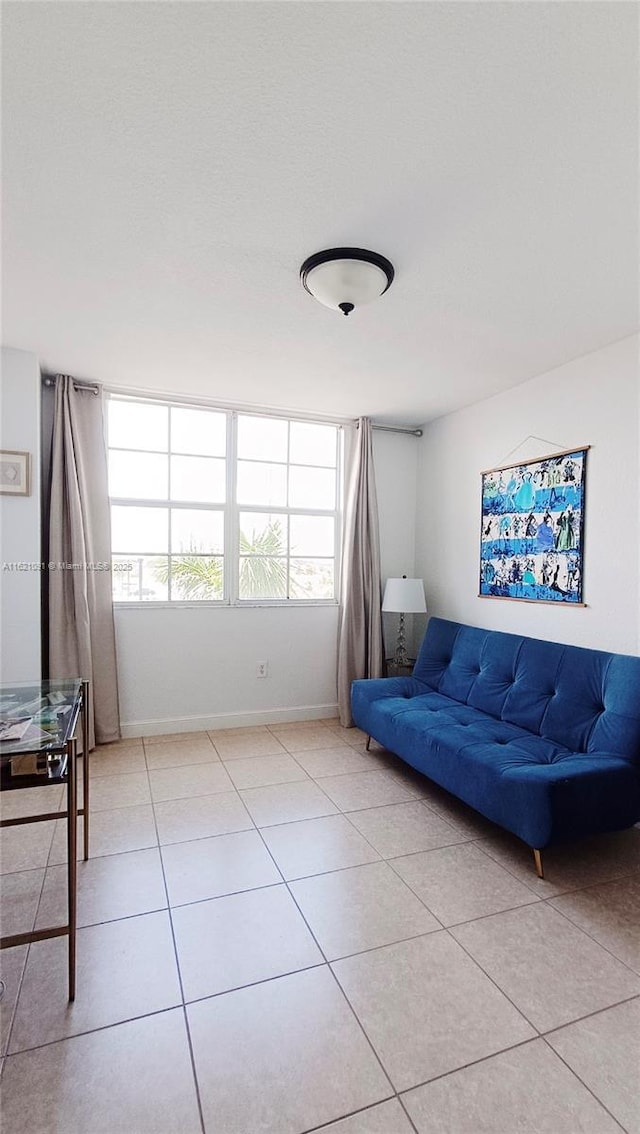 living area featuring baseboards and light tile patterned floors