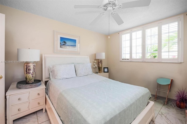 bedroom featuring a textured ceiling, ceiling fan, and light tile patterned floors