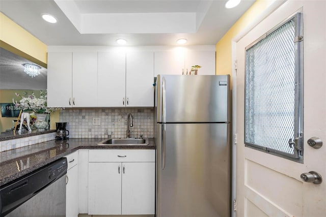 kitchen with sink, appliances with stainless steel finishes, a raised ceiling, and backsplash