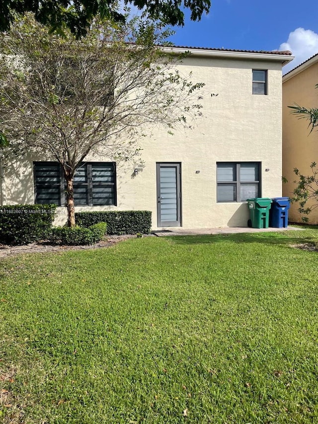 rear view of property featuring a yard and a patio