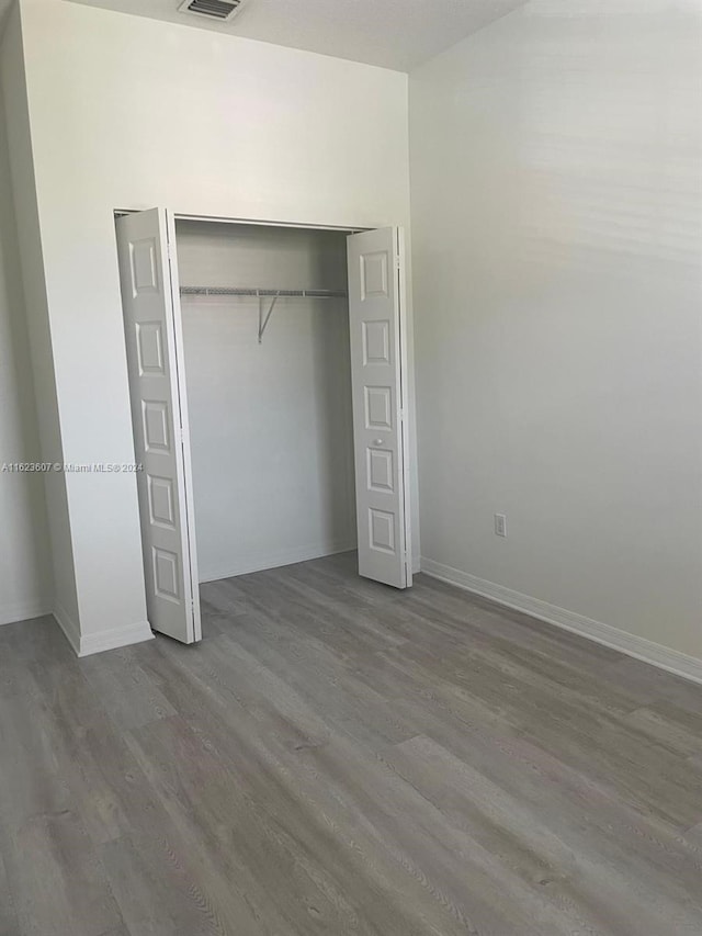 unfurnished bedroom featuring hardwood / wood-style floors and a closet