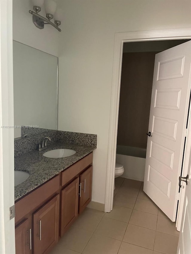 bathroom featuring toilet, a tub to relax in, vanity, and tile patterned floors