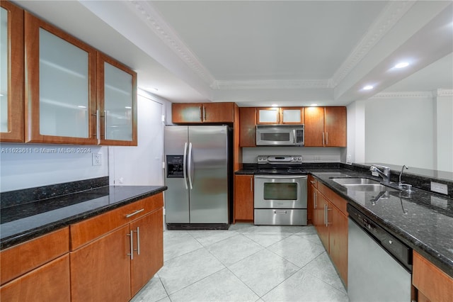 kitchen with dark stone counters, sink, stainless steel appliances, a raised ceiling, and light tile patterned floors