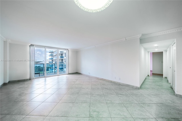 unfurnished room with light tile patterned floors, baseboards, and ornamental molding