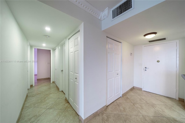 hall with visible vents, recessed lighting, and light tile patterned floors
