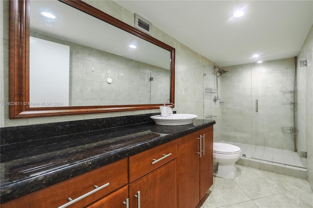 bathroom featuring tile walls, vanity, tile patterned flooring, toilet, and an enclosed shower