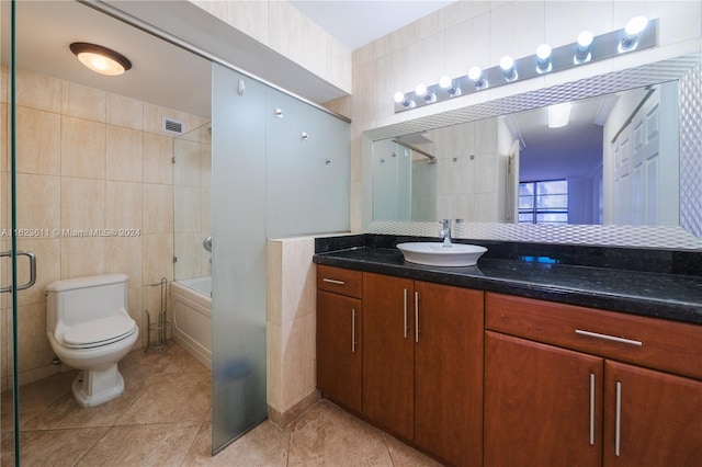 full bathroom with enclosed tub / shower combo, vanity, tile patterned floors, tile walls, and toilet