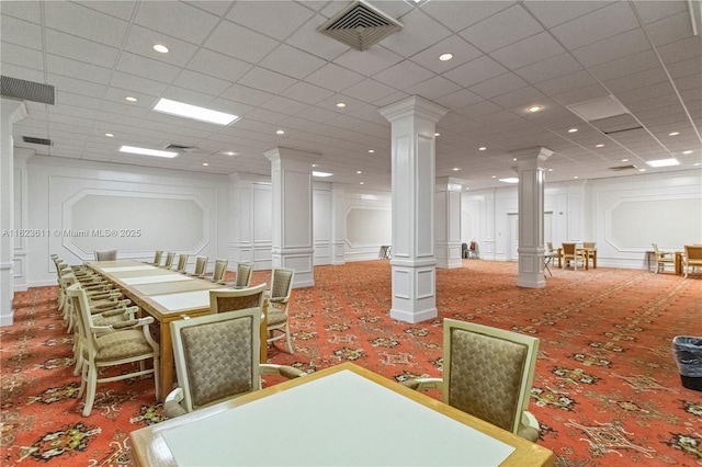 dining area featuring a decorative wall, carpet flooring, ornate columns, and visible vents