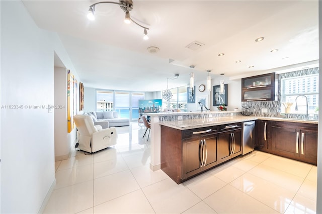 kitchen featuring kitchen peninsula, hanging light fixtures, sink, and a healthy amount of sunlight