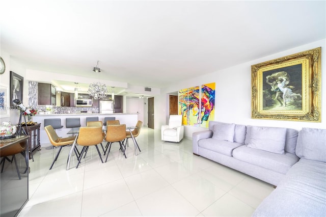 living room featuring a notable chandelier and light tile patterned floors