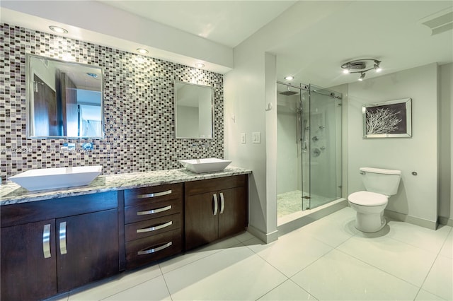 bathroom featuring walk in shower, vanity, toilet, and decorative backsplash