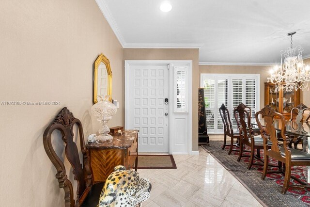 tiled foyer featuring crown molding and a chandelier