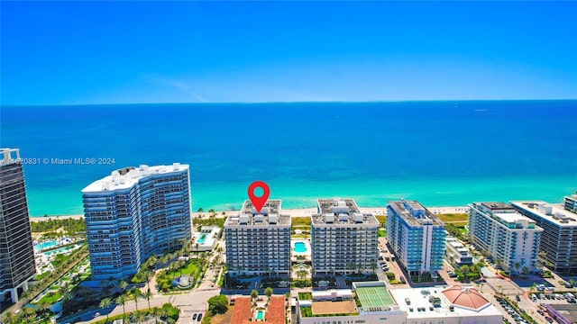 birds eye view of property featuring a water view and a beach view