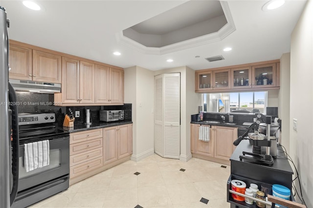 kitchen with dark stone countertops, a tray ceiling, electric range, and tasteful backsplash