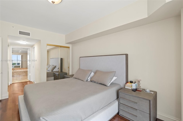 bedroom with a closet and dark hardwood / wood-style flooring