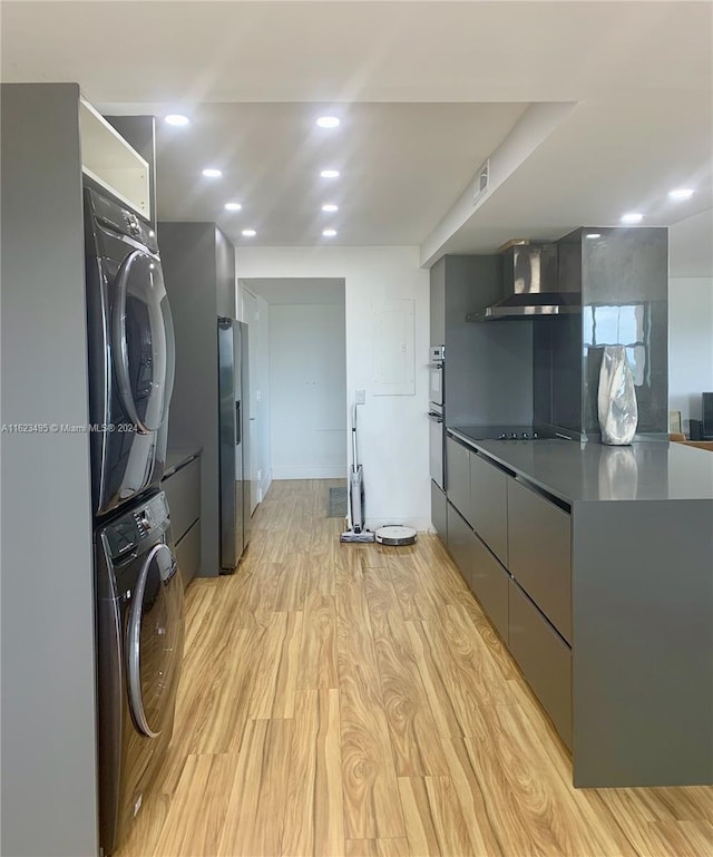 interior space featuring stacked washer and clothes dryer and light wood-type flooring