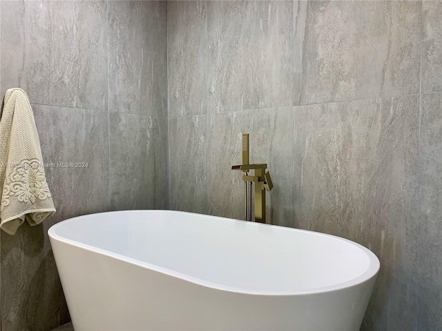 bathroom featuring a tub and tile walls