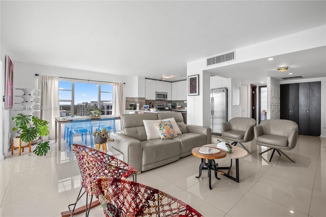 living area with a view of city, visible vents, and light tile patterned floors