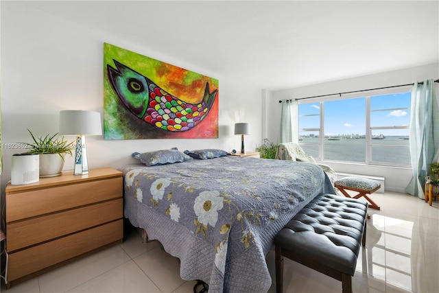 bedroom with a water view and light tile patterned flooring