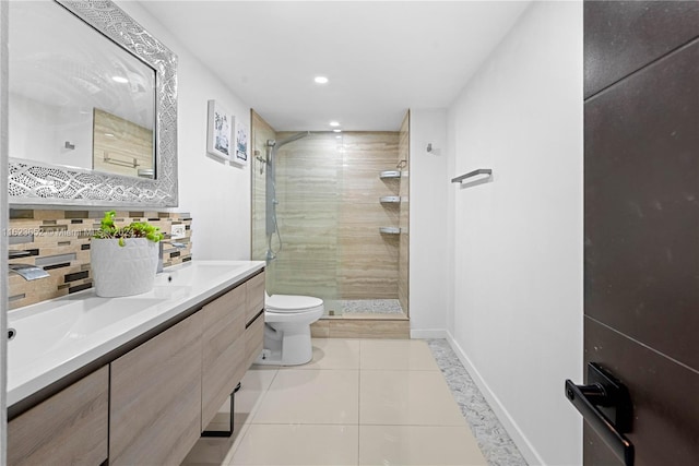 bathroom featuring vanity, tiled shower, tile patterned floors, decorative backsplash, and toilet