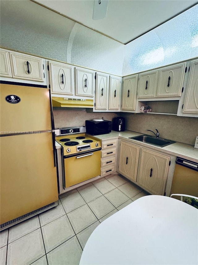 kitchen featuring sink, light tile patterned floors, dishwasher, stove, and fridge