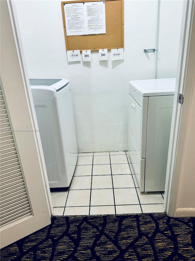 laundry area with light tile patterned floors and washer and clothes dryer