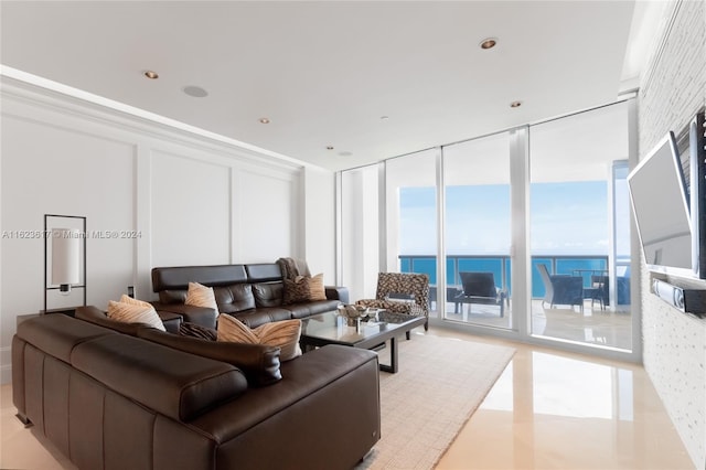 tiled living room with a wall of windows and a water view