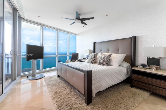 bedroom with a wall of windows, light tile patterned floors, and ceiling fan