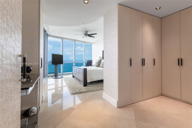 hall featuring light tile patterned floors and floor to ceiling windows