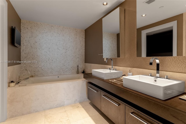 bathroom featuring a washtub, tile patterned flooring, and dual bowl vanity