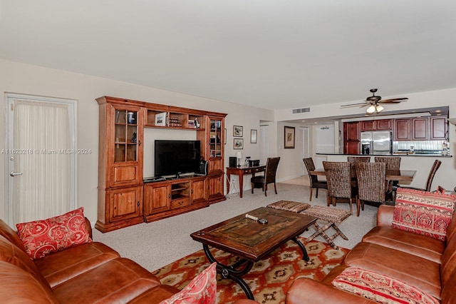 carpeted living room with ceiling fan