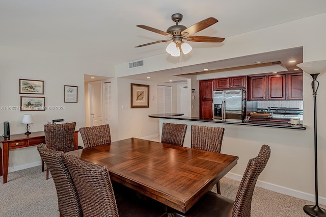 carpeted dining space featuring ceiling fan