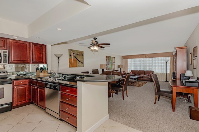 kitchen featuring kitchen peninsula, appliances with stainless steel finishes, ceiling fan, and light tile patterned floors