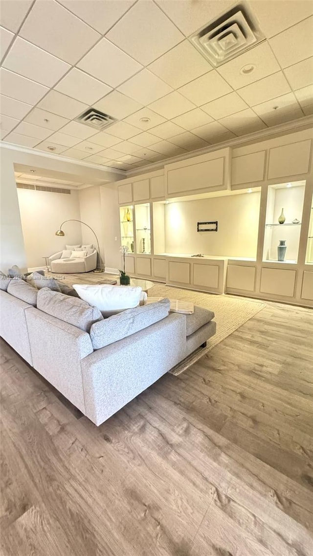 living room with hardwood / wood-style flooring, crown molding, and a paneled ceiling