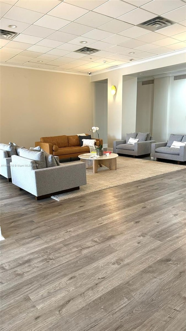 unfurnished living room featuring hardwood / wood-style flooring and a drop ceiling