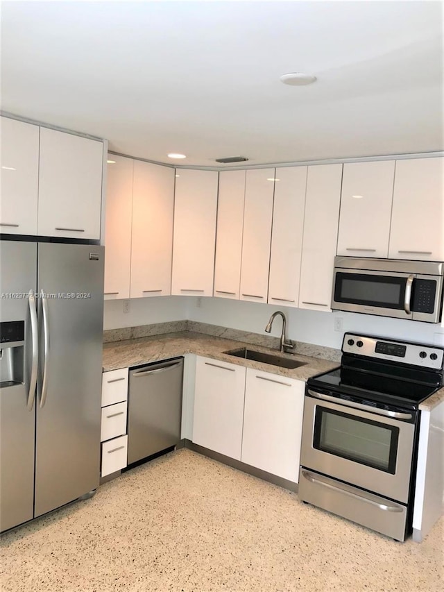 kitchen featuring appliances with stainless steel finishes, sink, and white cabinets