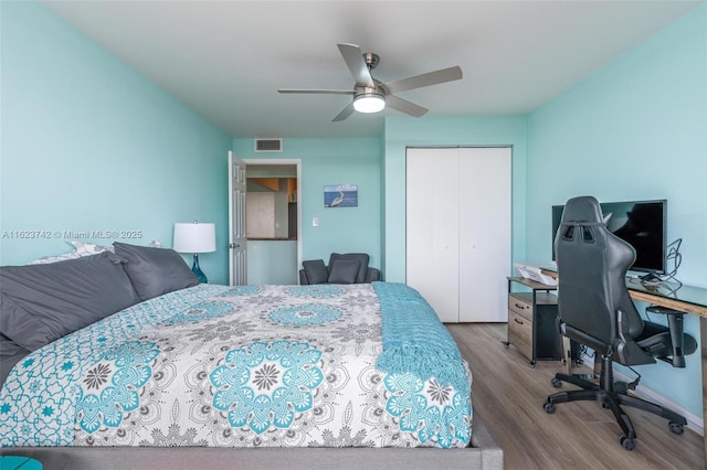 bedroom with hardwood / wood-style flooring, ceiling fan, and a closet