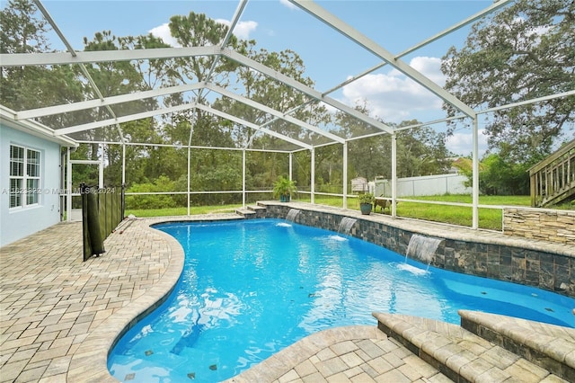 view of pool featuring a lawn, a patio, glass enclosure, and pool water feature