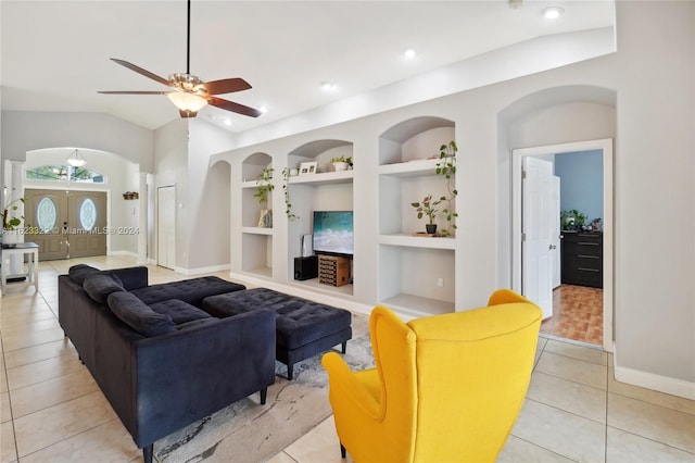 living room featuring built in shelves, vaulted ceiling, light tile patterned floors, and ceiling fan