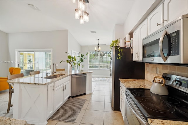 kitchen with sink, a chandelier, pendant lighting, appliances with stainless steel finishes, and white cabinetry