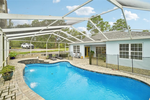 view of swimming pool featuring a lanai, pool water feature, and a patio area